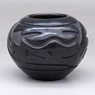 A black bowl carved with an avanyu and geometric design around the shoulder
 by Stella Chavarria of Santa Clara