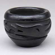 A small black bowl carved with an avanyu and geometric design around the body
 by Elizabeth Naranjo of Santa Clara
