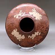 A wide, low-shouldered sepia jar decorated with a sgraffito four-panel pueblo dancer, plant and geometric design above the shoulder and sgraffito plant design below
 by Paul Naranjo of Santa Clara