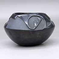 A black bowl carved above the shoulder with a two-panel geometric design, click or tap to see a larger version