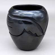 A black jar carved with a stylized avanyu design around the shoulder
 by Mida Tafoya of Santa Clara