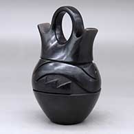 A black wedding vase carved with an avanyu design around the body, click or tap to see a larger version