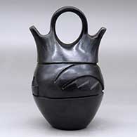 A black wedding vase carved with an avanyu design around the body, click or tap to see a larger version