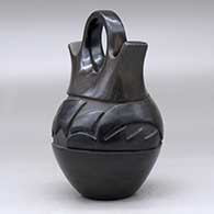 A black wedding vase carved with an avanyu design around the body, click or tap to see a larger version