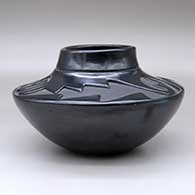 A high-shoulder black jar with a three-panel geometric design carved above the shoulder, click or tap to see a larger version