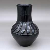 A black vase carved above the shoulder with a ring of feathers design
 by Belen Tapia of Santa Clara