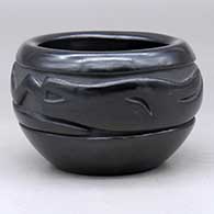 A black bowl with a carved avanyu design around the body
 by Betty Naranjo of Santa Clara