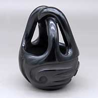 A black engagement basket carved with a two-panel geometric design around the body
 by Pablita Chavarria of Santa Clara