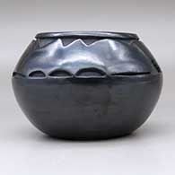 A black bowl carved with a stylized avanyu design above the shoulder, click or tap to see a larger version