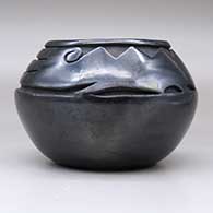 A black bowl carved with a stylized avanyu design above the shoulder, click or tap to see a larger version