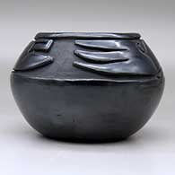 A black bowl carved with a stylized avanyu design above the shoulder, click or tap to see a larger version