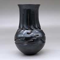 A tall-neck black jar carved with an avanyu design above the shoulder and a ring of feathers design around the neck, click or tap to see a larger version