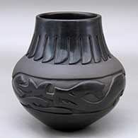 A polished and matte black jar decorated with a carved avanyu, feather and geometric design
 by Sharon Naranjo Garcia of Santa Clara