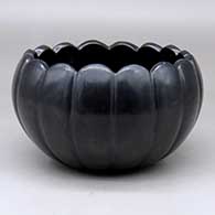 A black melon bowl carved with 16 ribs and a scalloped rim
 by Sherry Tafoya of Santa Clara
