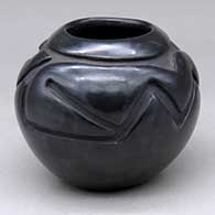 A small black jar with a stylized avanyu design carved around and above the shoulder
 by Christina Naranjo of Santa Clara