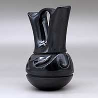 A black wedding vase carved around the body with an avanyu design, click or tap to see a larger version
