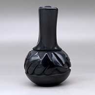 A black wedding vase carved around the body with an avanyu design, click or tap to see a larger version