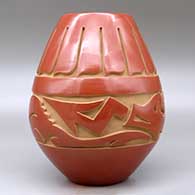 A red jar carved around the body with an avanyu and feather design, click or tap to see a larger version
