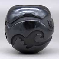 A black jar carved around the body with an avanyu design, click or tap to see a larger version
