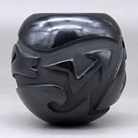 A black jar carved around the body with an avanyu design, click or tap to see a larger version