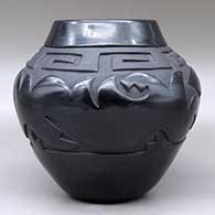 A black on black jar carved with an avanyu, scroll and geometric design, Second Prize ribbon from the Gallup InterTribal Ceremonial, click or tap to see a larger version