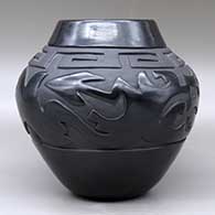 A black on black jar carved with an avanyu, scroll and geometric design, Second Prize ribbon from the Gallup InterTribal Ceremonial, click or tap to see a larger version