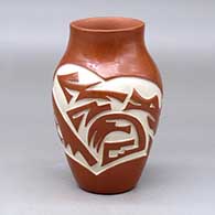 A red vase carved with an avanyu and geometric design around the body
 by Tina Diaz of Santa Clara