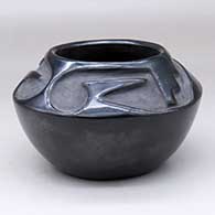 A black bowl carved with a two-panel geometric design above the shoulder
 by Rose Gonzales of San Ildefonso