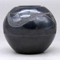 A black bowl decorated with an inlaid stone and a sgraffito plumed avanyu, cloud formation and geometric design , click or tap to see a larger version