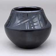 A black on black bowl decorated with a four-panel geometric design above the shoulder
 by Desideria Montoya of San Ildefonso