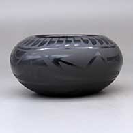 A black on black bowl decorated around the body with a plumed avanyu, ring of feathers, cloud formation and geometric design, click or tap to see a larger version