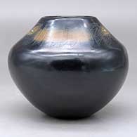 A black jar with sienna spots and inlaid stones, decorated above the shoulder with a sgraffito avanyu, feather, fineline and geometric design, click or tap to see a larger version