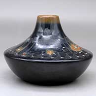 A low shouldered black jar with a sienna rim and spots, inlaid stones and decorated with a sgraffito avanyu, feather, spider and geometric design, click or tap to see a larger version