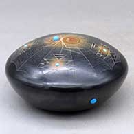 A black seed pot with sienna spots, inlaid stones and a sgraffito spider, spider web and geometric design, click or tap to see a larger version