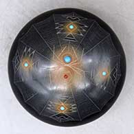 A black seed pot with sienna spots, inlaid stones and a sgraffito spider, spider web and geometric design
 by Barbara Gonzales of San Ildefonso