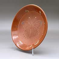 A red and micaceous red shallow bowl decorated with inlaid stones and a sgraffito butterfly and geometric design, click or tap to see a larger version