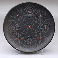 A black micaceous plate with inlaid stones and a sgraffito spider and geometric design
 by Barbara Gonzales of San Ildefonso