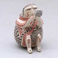 A miniature polychrome matachine holding a cup and decorated with a fineline and geometric design
 by Carla Martinez of Mata Ortiz and Casas Grandes