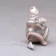 A miniature polychrome matachine figure decorated with a fineline geometric design and with a hummingbird hovering nearby, click or tap to see a larger version
