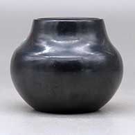 A small black jar decorated with a sienna spot and an inlaid stone, click or tap to see a larger version