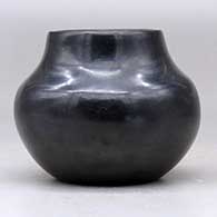 A small black jar decorated with a sienna spot and an inlaid stone, click or tap to see a larger version