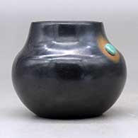 A small black jar decorated with a sienna spot and an inlaid stone, click or tap to see a larger version
