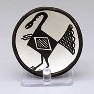 A small black-on-white plate decorated with a bird and geometric design
 by Lucy Lewis of Acoma