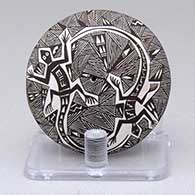 A miniature black-on-white seed pot decorated with a lizard, fine line and geometric design
 by Rebecca Lucario of Acoma