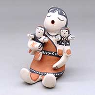 A sitting grandmother storyteller figure with two children
 by Snowflake Flower of Cochiti