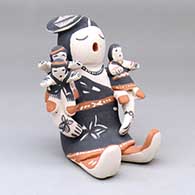 A sitting grandmother storyteller figure with three children
 by Snowflake Flower of Cochiti