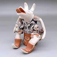 A sitting coyote storyteller figure with six children and a butterfly
 by Snowflake Flower of Cochiti