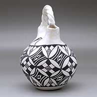 A black-on-white wedding vase with a twisted bridge and decorated with a pumpkin seed snowflake and geometric design, click or tap to see a larger version