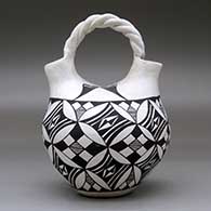 A black-on-white wedding vase with a twisted bridge and decorated with a pumpkin seed snowflake and geometric design, click or tap to see a larger version