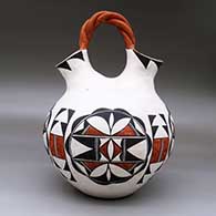 A polychrome wedding vase with a twisted bridge and decorated with a four-panel geometric design, click or tap to see a larger version